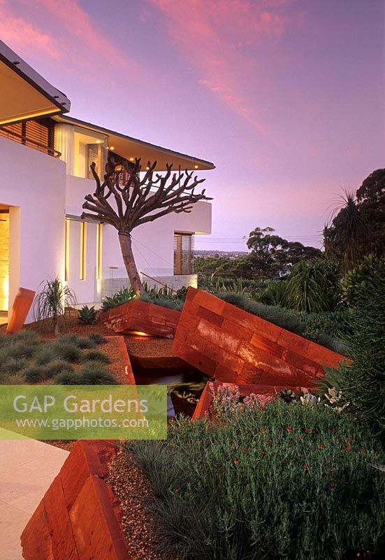 Contemporary garden with orange angular walls and water feature - Sydney 