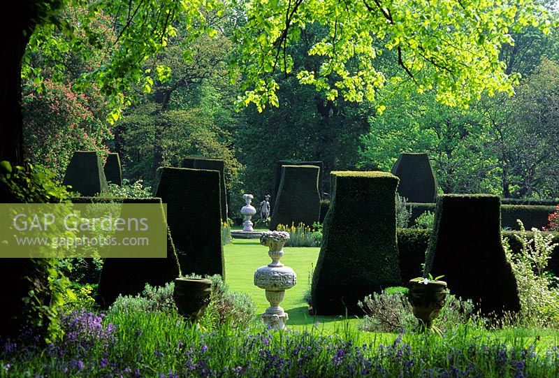 Formal garden with large topiarised Taxus baccata shapes in lawn and statues as focal points - Renishaw Hall, Derbyshire 