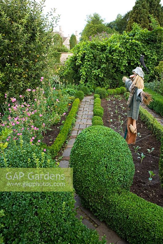 The potager with scarecrow and brick paving - Barnsley House Gardens, Gloucestershire