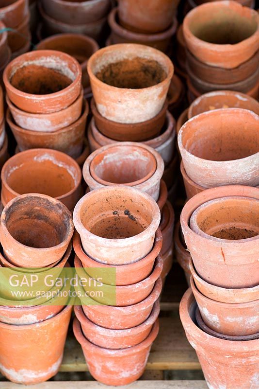 Piles of terracotta pots in greenhouse