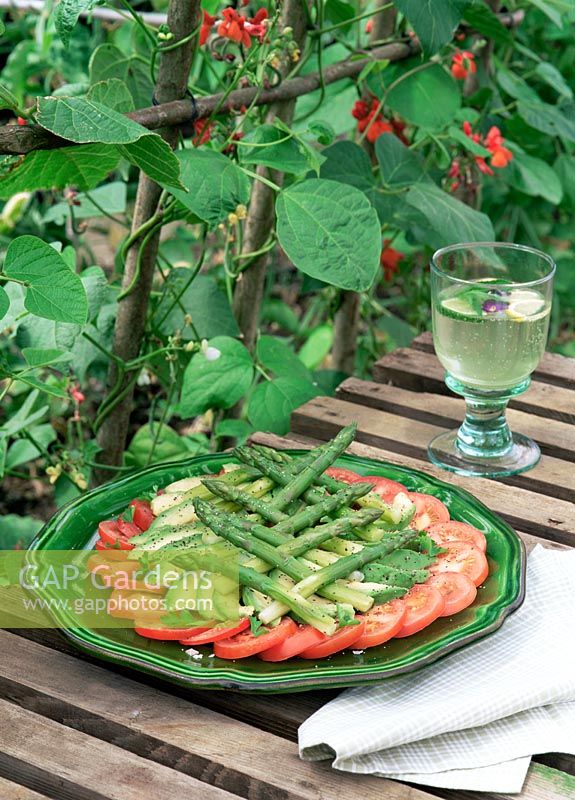 Fresh salad with Tomatoes, Asparagus and Avocado with backdrop of Runner Beans