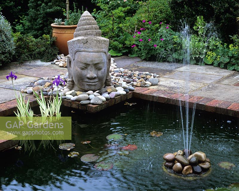 Pond with fountain and Asian head sculpture