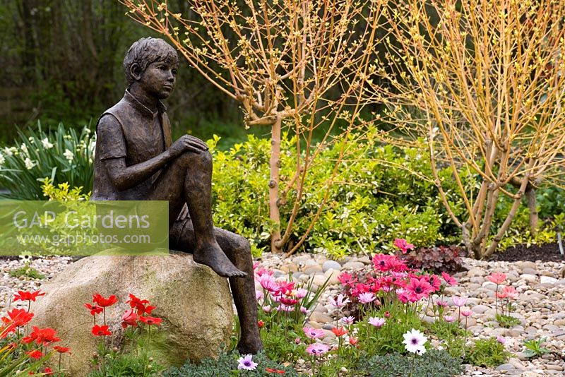 'Boy on a Rock' by Jane Hogben with Anemone pavonina and the stems of Cornus sanguinea 'Midwinter Fire'