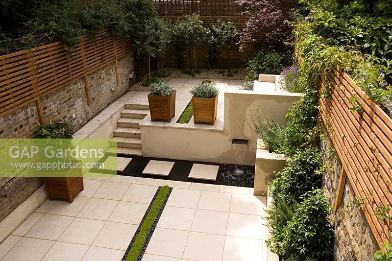 Contemporary garden with planted rill, copper water feature, portuguese limestone paving and steps. Design Charlotte Rowe