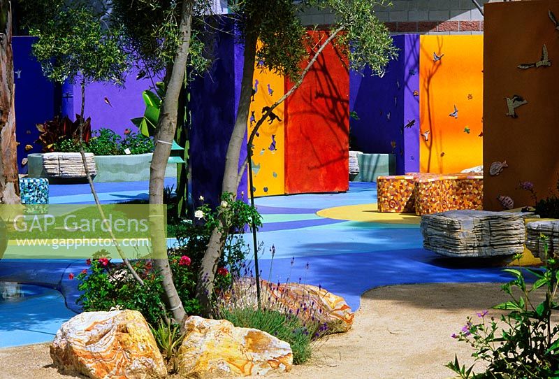 Colourful contemporary childrens garden with seating and raised borders 