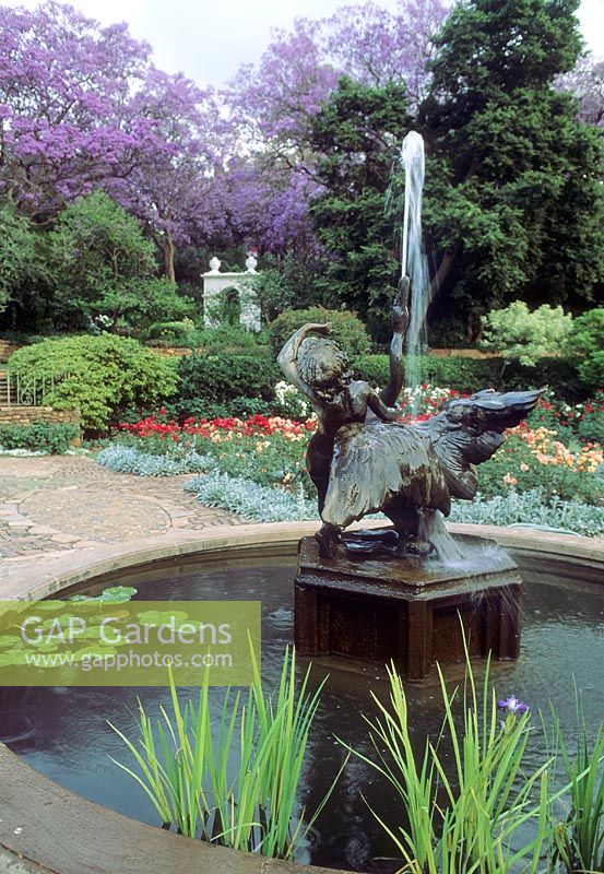 Formal circular pond with statue and fountain. Jacaranda in bloom - Brenthurst, Johannesburg, Republic of South Africa