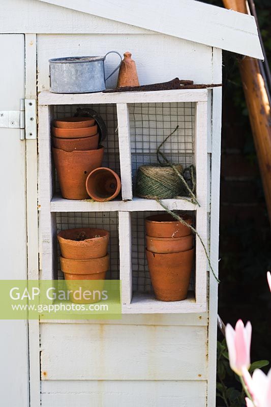 Improvised shelves adding interest and usefulness to exterior of garden shed