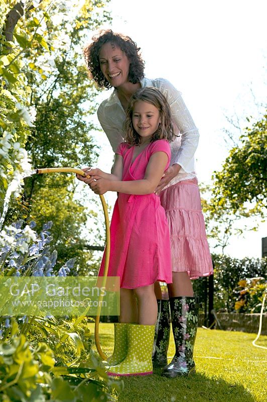 Mother and daughter with hose