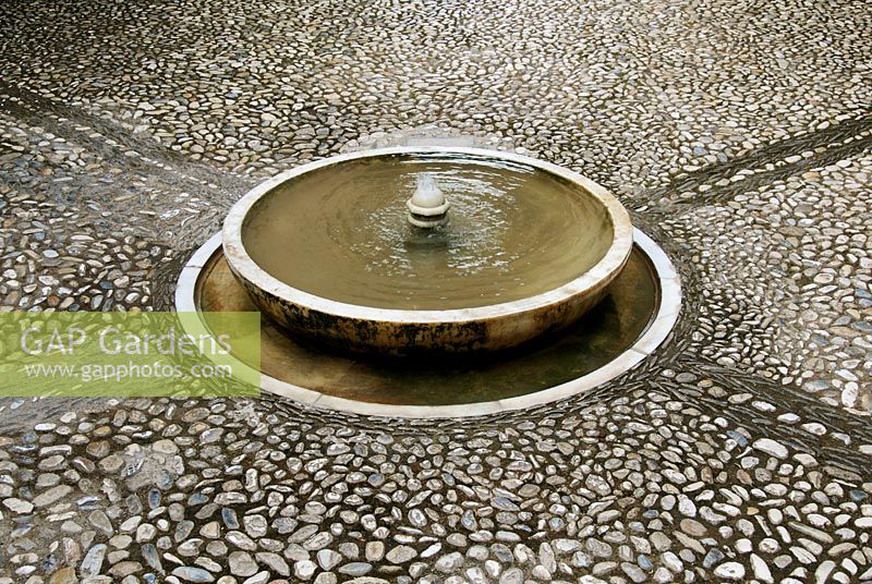 Circular fountain in cobbled courtyard of the Generalife Gardens - Gardens of the Alhambra, Granada, Spain 