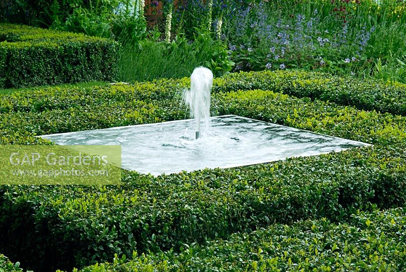 Water feature in square steel container surrounded by Buxus topiary - The Fortnum and  Mason Garden, Chelsea 2007