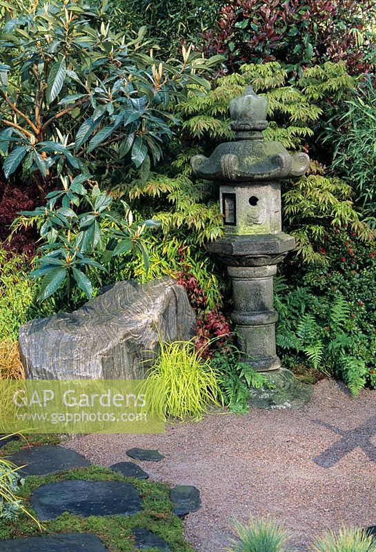 Japanese inspireret garden with stone lantern, rocks and foliage planting   