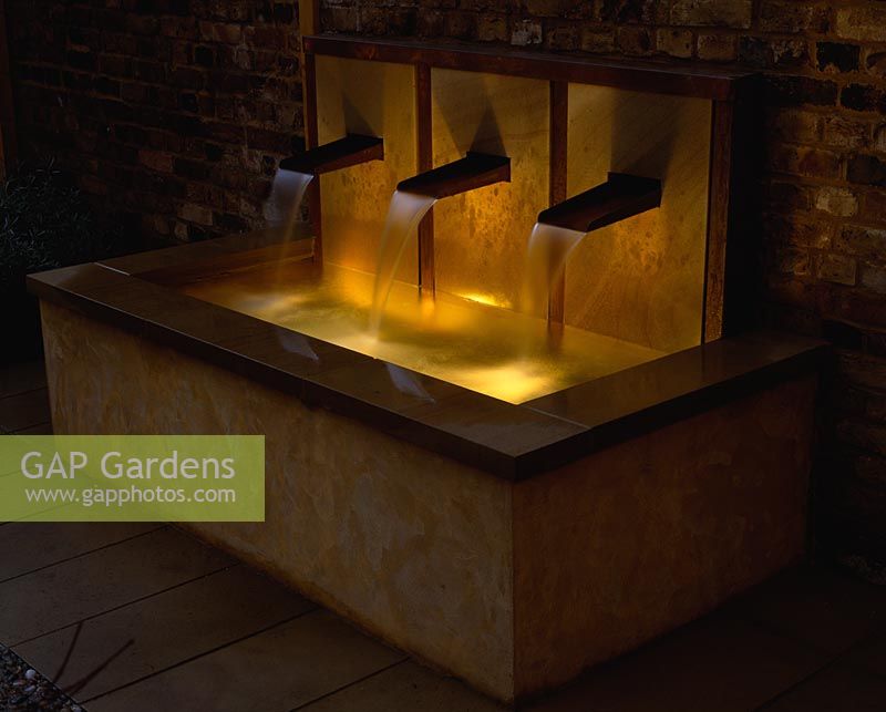 Raised water feature with three copper spouts, cascading water into rectagular pool - Lit with underwater lighting