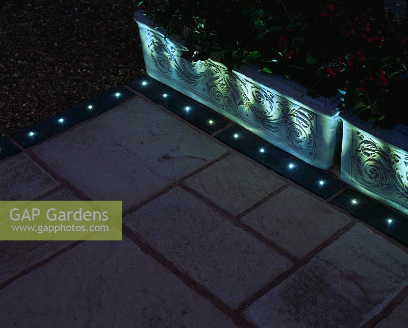 Patio and container with built-in lights into the edge of the paving