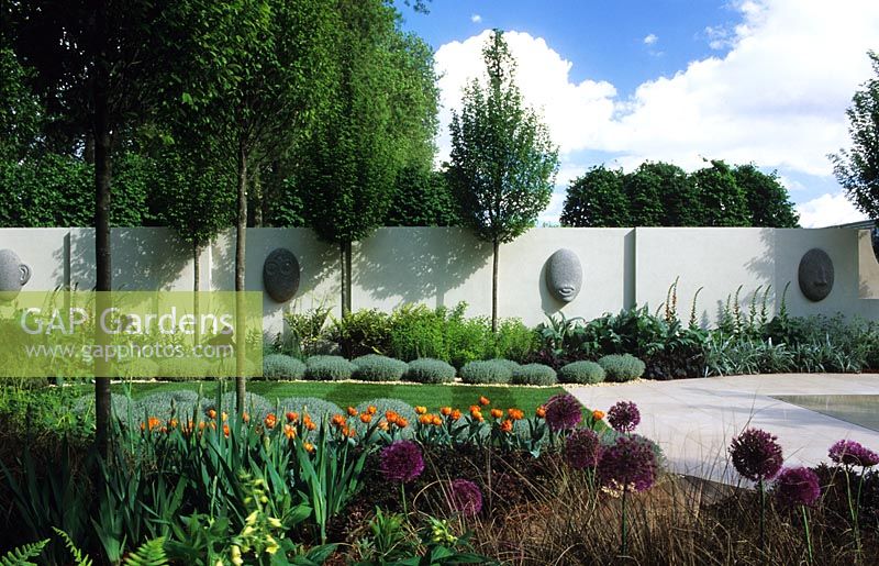 Contemporary minimal garden with patio sculpture clipped hornbeams and perennial planting - Chelsea 2002 