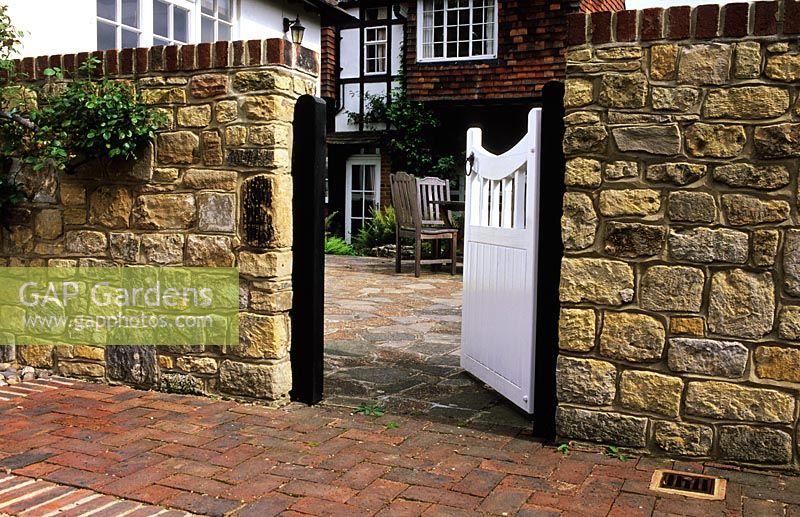 Courtyard patio garden with stone wall and gate - Lower Courts, Surrey 