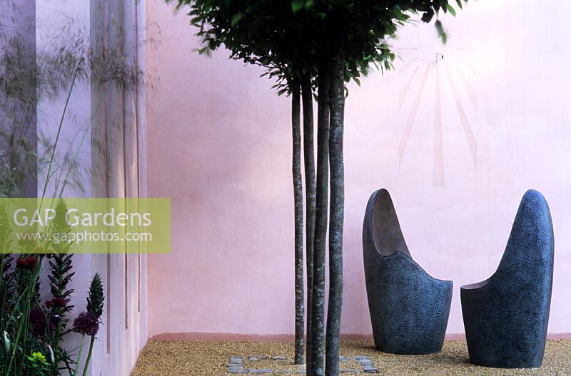 Sculpted chairs by Dennis Fairweather with clipped hornbeams and pink colour washed walls 