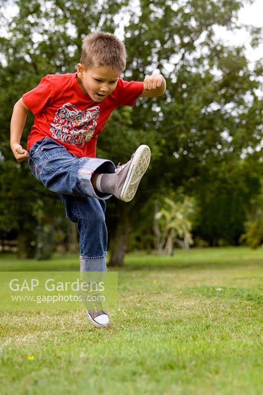 Young boy kicking football