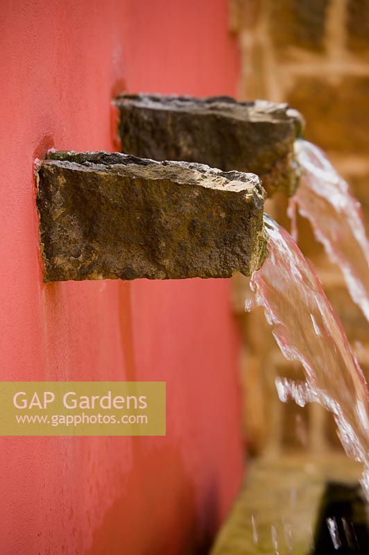 Water feature in red wall 