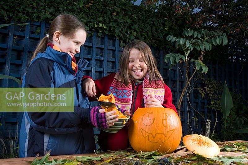 Girl scooping seeds from pumpkin, sequence of making Halloween lantern