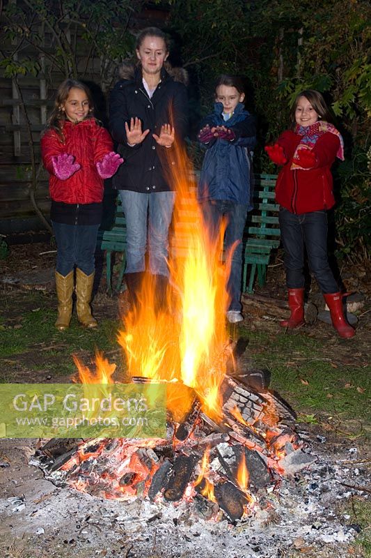 Bonfire and girls warming hands