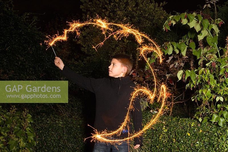 Boy playing with sparklers in the dark