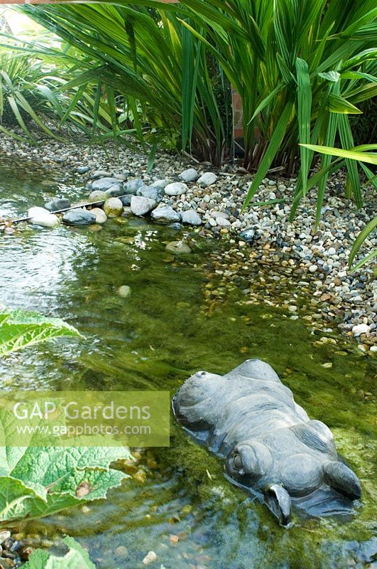 Pool designed to look like pebble stream with Hippopotamus ornament in water