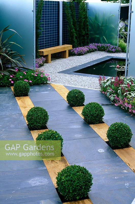 Buxus balls in slate and timber paving leading to sqaure pond - 'Then and Now' garden, Hampton Court 2007