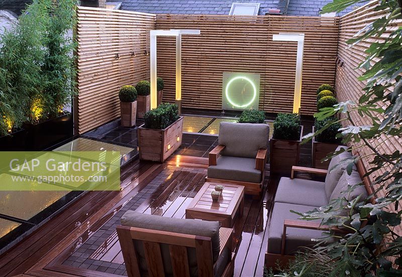 Contemporary modern small urban roof garden with decking, seating, lighting, Buxus spheres in containers - Wilton Place London