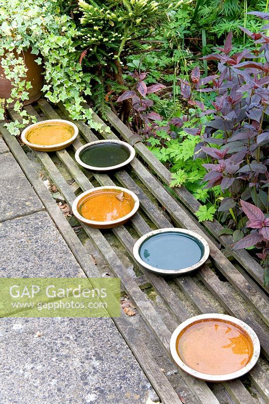 Coloured pot holders used as decoration or bird bath