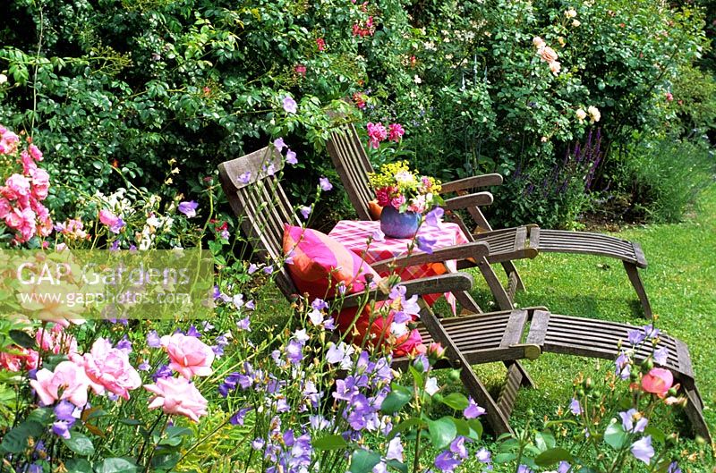 Two reclining chairs in a summer garden