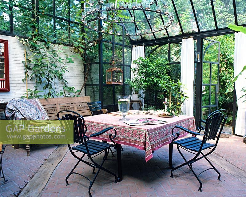 A formal winter garden with glass roof and seating area