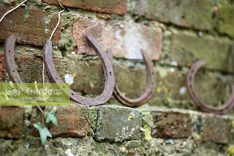 Rusty horseshoes sat on ledge on brick wall