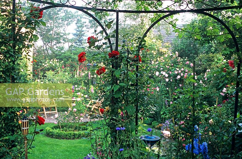 Pavillon with climbing roses in country garden