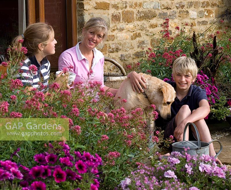 Family relaxing in the garden with their pet dog