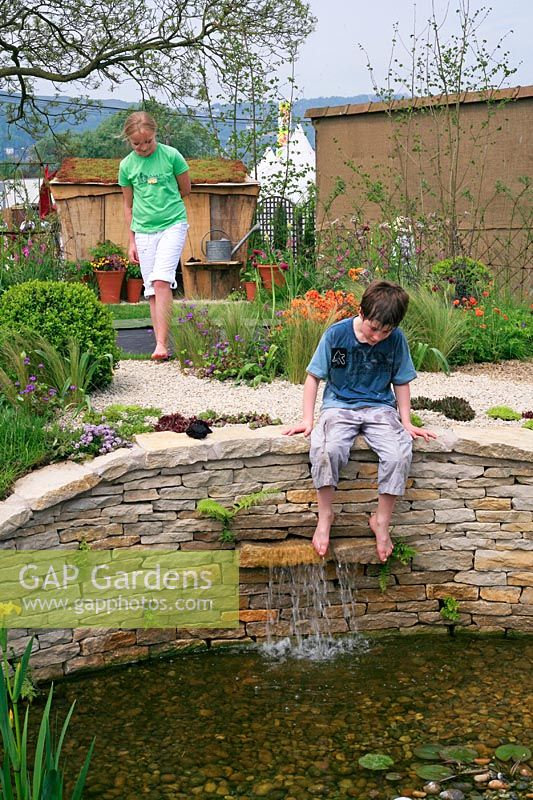 Childrens' garden with boy playing with water