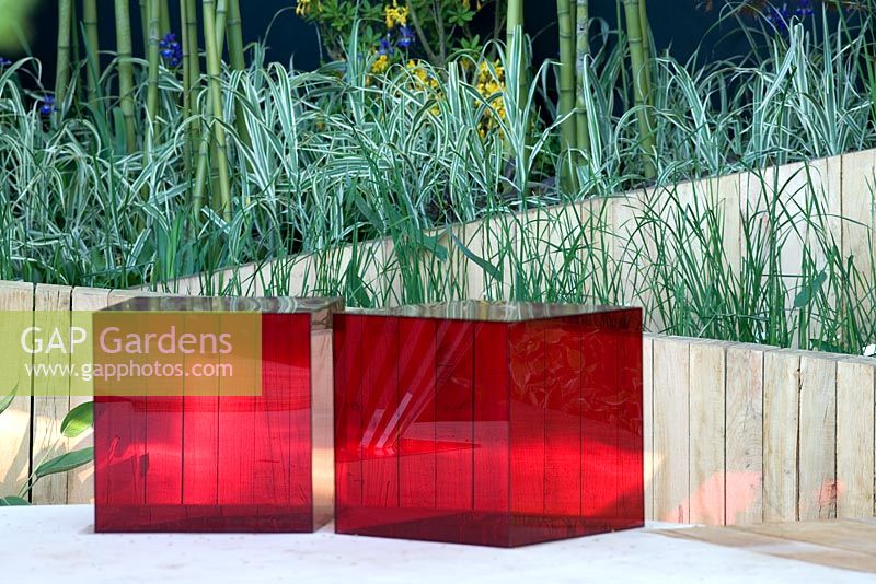 Two red perspex blocks as seats against a curved oak wall. Garden - The Lloyd's TSB Garden Travellers Retreat, RHS Chlesea Flower Show 2008. Design - Trevor Tooth, Sponsor - Lloyds TSB