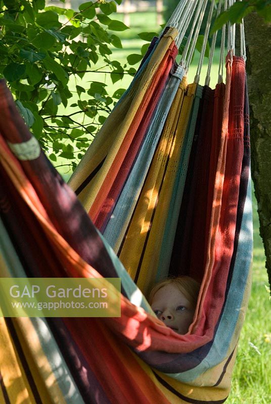 Girl in a colourful striped hammock