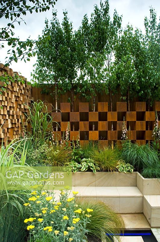 Chequered screen with trees and seating area - The Pemberton Greenish Recess Garden, RHS Chelsea Flower Show 2008