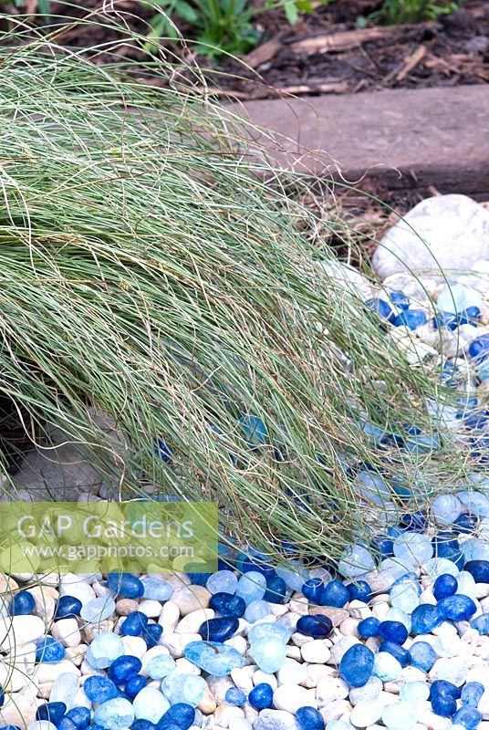 Blue pebbles under ornamental grass