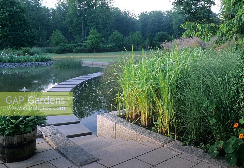 Stepping stone path floating over water of pond -  Hakansson garden, The Farstorp Estate, South Sweden