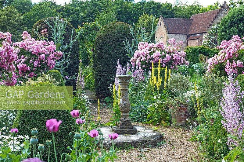 The sundial surrounded by summer flowers in June - Chenies Manor Gardens