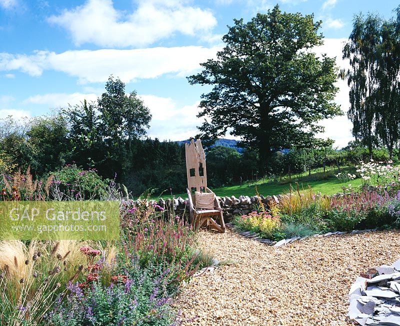 The gravel garden, wall and wooden 'Throne' chair with the blackdown hills behind