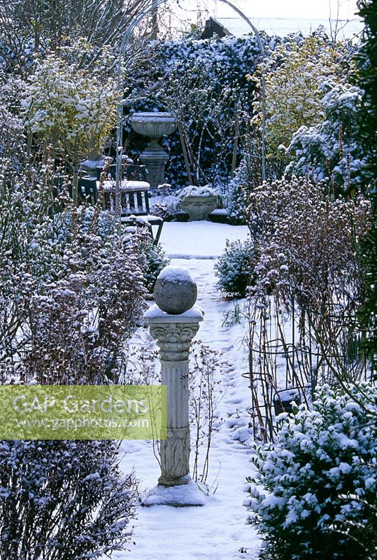 View to arch along path with sundial in snow - Woodchippings, Northamptonshire