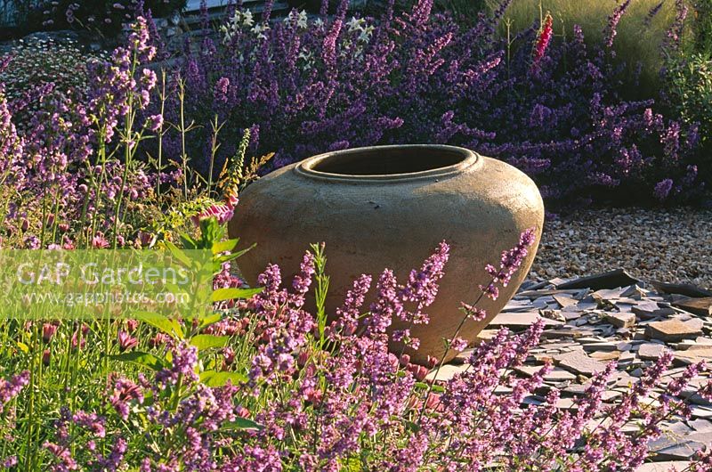 Gravel garden with Nepeta 'Walkers Low', slate and large empty urn