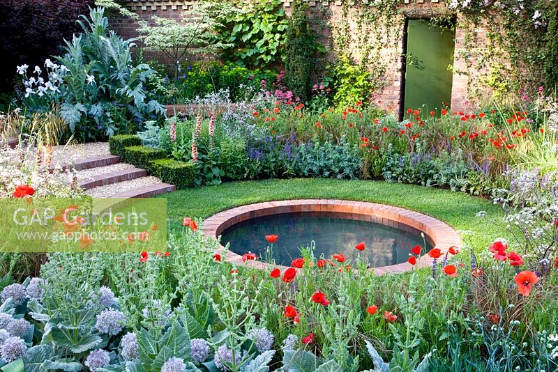 Circular brick lined pond surrounded by mixed border - The Largest Room in the House Garden - Chelsea Flower Show 2008, Sponsors - GMI Property Company, The Royal British Legion, Toc H 
