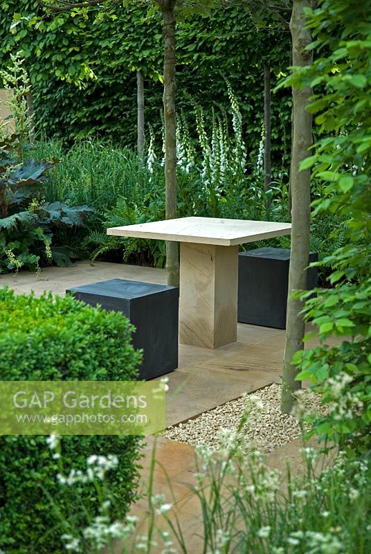 Modern seating and table in quiet corner of shaded garden, The Reflective Garden Sponsor - Ruffer LLP - RHS Chelsea Flower Show 2008