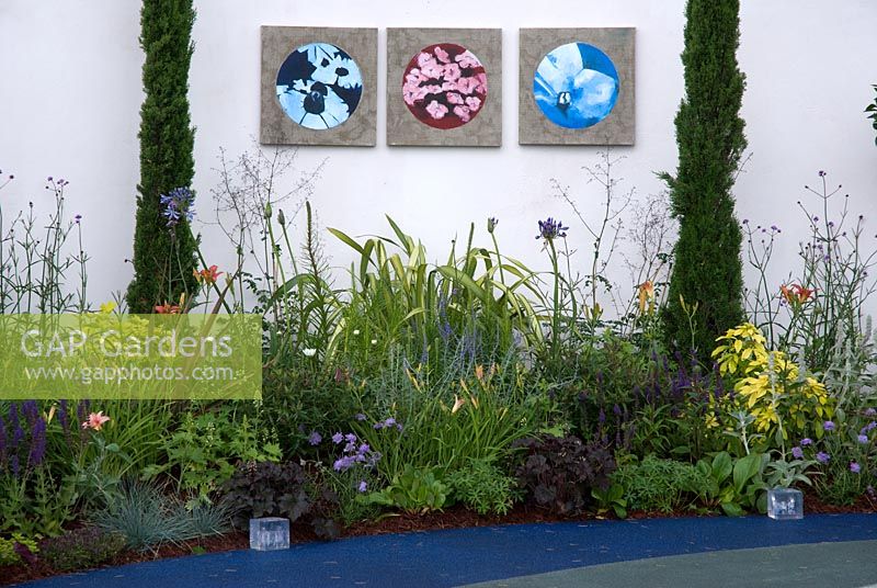 Mixed perennial border with outdoor wall hangings - Sustainability can be Sexy Garden - Hampton Court Flower Show 2008