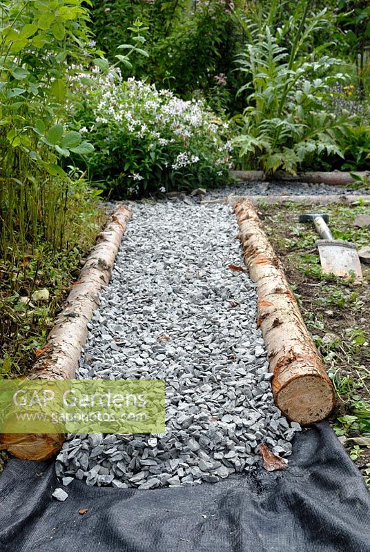Laying a garden path with rustic timbers, gravel and weed control membrane