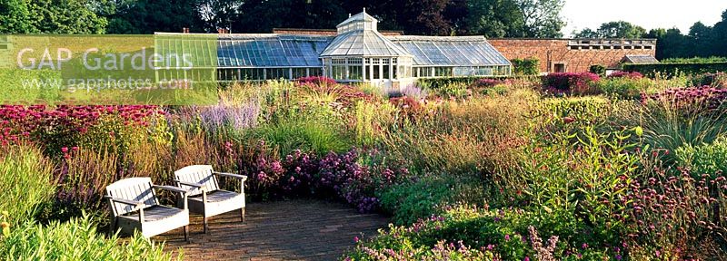 Seating area and Glasshouse in The Perennial Meadow at Scampston Hall designed by Piet Oudolf