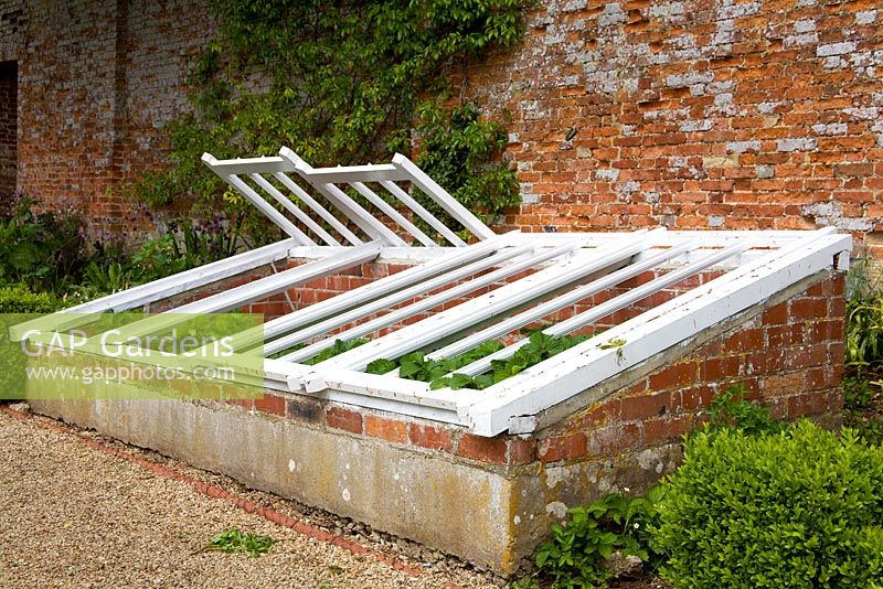 Old wood and brick cold frames in traditional kitchen garden
